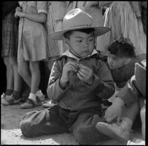 Manzanar Relocation Center, Manzanar, California. A little girl evacuee of Japanese descent watches . . . - NARA - 538551