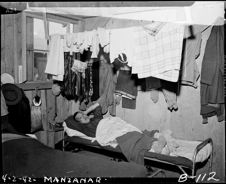 Manzanar Relocation Center, Manzanar, California. An evacuee resting on his cot after moving his be . . . - NARA - 536861