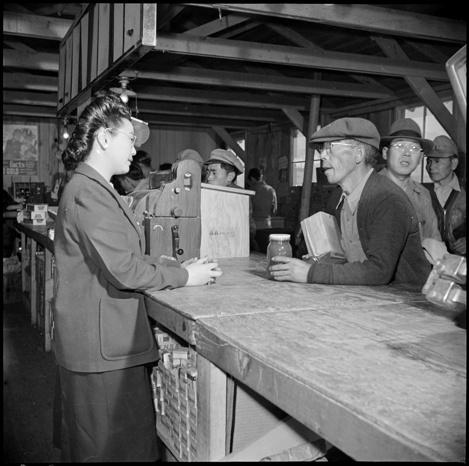 Manzanar Relocation Center, Manzanar, California. An elderly evacuee purchases peanut butter for a . . . - NARA - 536927