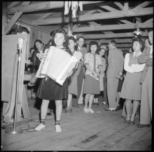 Manzanar Relocation Center, Manzanar, California. A young evacuee of Japanese ancestry entertains o . . . - NARA - 538574 photo