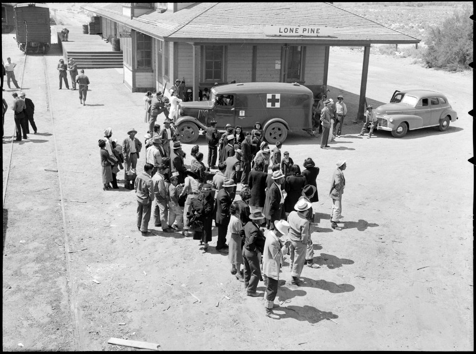 Manzanar Relocation Center, Manzanar, California. Evacuees of Japanese ancestry await bus for Manza . . . - NARA - 538489