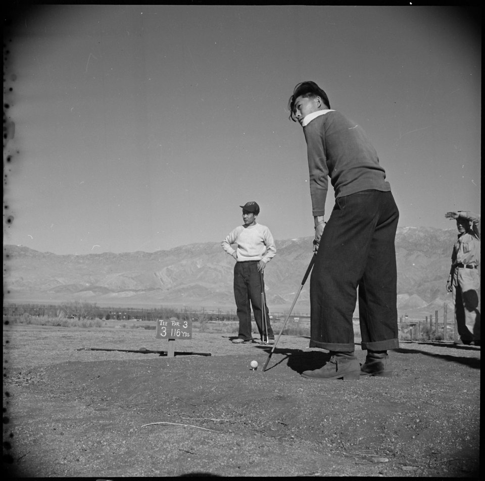 Manzanar Relocation Center, Manzanar, California. Golfing enthusiasts enjoy a friendly game of golf . . . - NARA - 536945