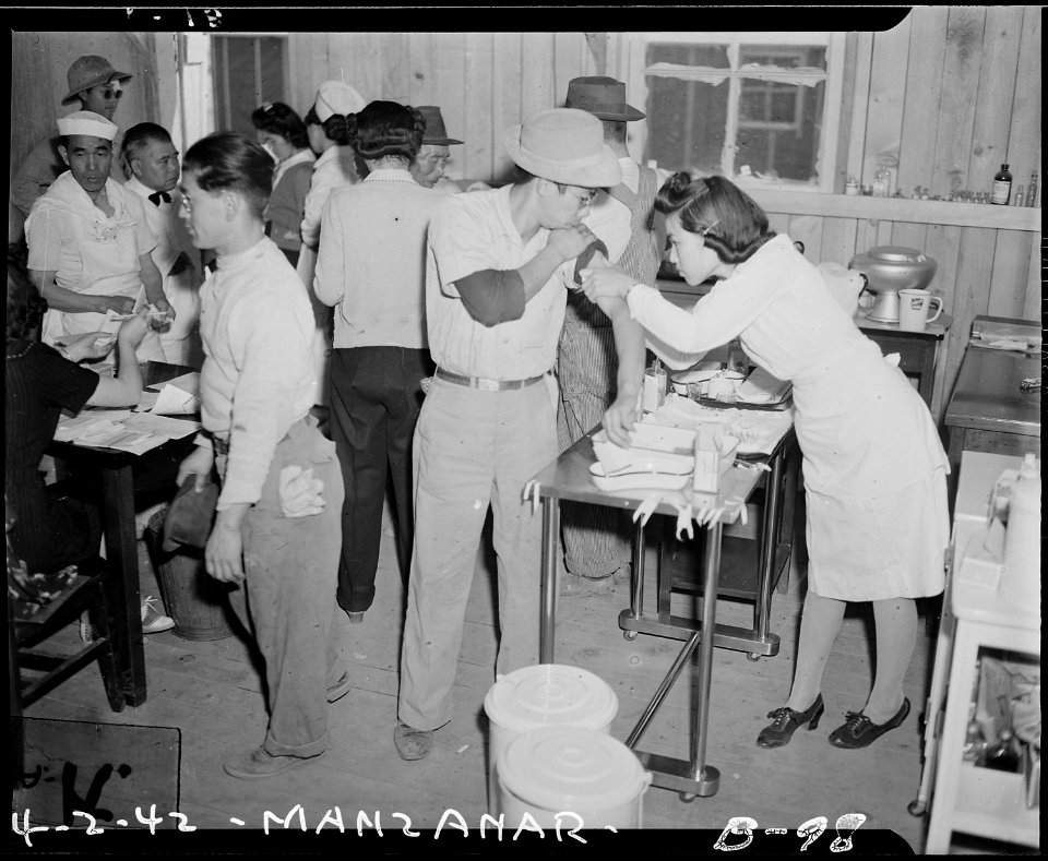 Manzanar Relocation Center, Manzanar, California. Newcomers vaccinated by fellow and sister evacuee . . . - NARA - 536847