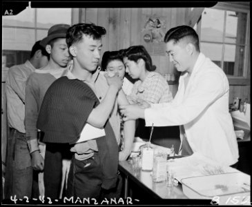 Manzanar Relocation Center, Manzanar, California. Newcomers are vaccinated by evacuee nurses and do . . . - NARA - 536899