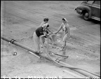 Manzanar Relocation Center, Manzanar, California. Relocated Nisei girls getting a bucket of water f . . . - NARA - 536759