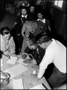 Manzanar Relocation Center, Manzanar, California. Signing for bedding at Manzanar, a War Relocation . . . - NARA - 538490