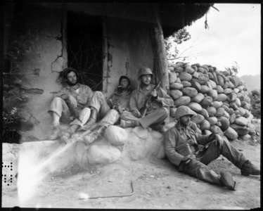Marines of the 1st Marine Division relax by a Korean hut after destroying an enemy sniper housed there. - NARA - 532424