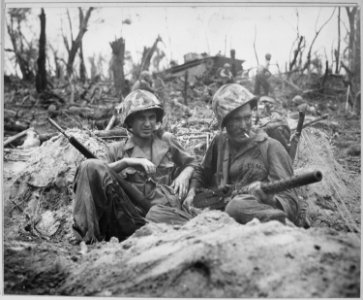 Marine Private First Class Douglas Lightheart (right) cradles a 30-caliber machine gun in his lap, while he and his... - NARA - 532538