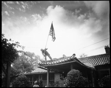 Marine Private First Class Luther Leguire raises U.S. Flag at American consulate in Seoul, while fighting for the... - NARA - 532406 photo