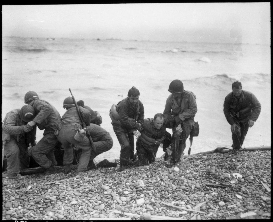 Members of an American landing party lend helping hands to others whose landing craft was sunk by enemy action off... - NARA - 531189