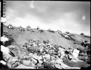 Marines of the 5th Division inch their way up a slope on Red Beach No. 1 toward Surbachi Yama as the smoke of the... - NARA - 532543