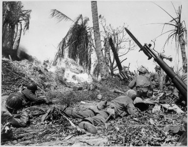 Men of the 7th Division using flame throwers to smoke out Japanese from a block house on Kwajalein Island, while... - NARA - 531319