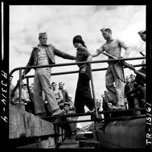 Marines unloading Japanese POW from a submarine returned from a war patrol. - NARA - 520838 photo