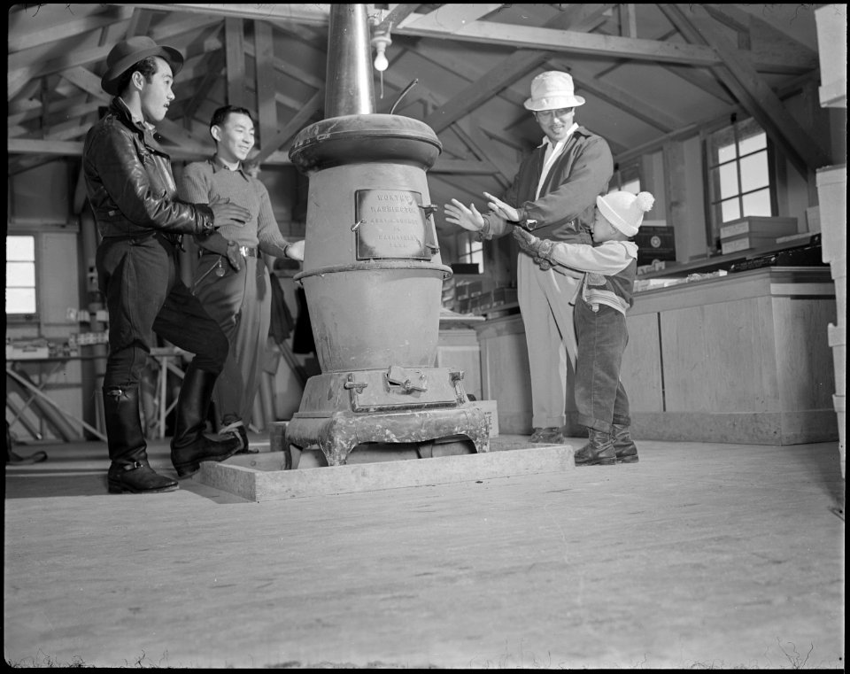 Minidoka Relocation Center. Community store block 30. Customers warming hands by stove. - NARA - 536573
