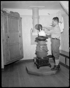 Minidoka Relocation Center. Eizo Nishi. View in the home of Eizo Nishi. The pot bellied stove sho . . . - NARA - 536577