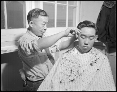 Minidoka Relocation Center. J. K. Kimura, Head barber. Ted Arai. Barber shop. - NARA - 536566