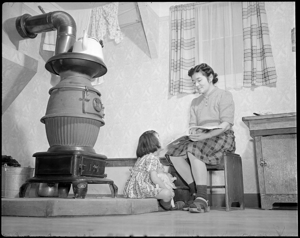Minidoka Relocation Center. Mrs. Eizo Nishi, Eime, four, daughter. Mrs. Nishi reads a bedtime stor . . . - NARA - 536562