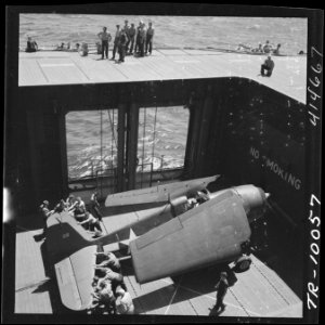 Navy crewmen aboard the USS Monterey (CVL-26) bringing an F6F to the flight deck on elevator. - NARA - 520750