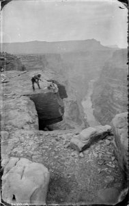 Near Foot of Toroweap, looking east at Grand Canyon. The two men are seated, one with notebook^ and the other bent... - NARA - 517798