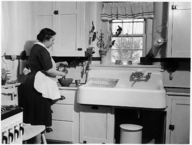 No original caption. (Woman cooking in a kitchen.) - NARA - 513406 photo