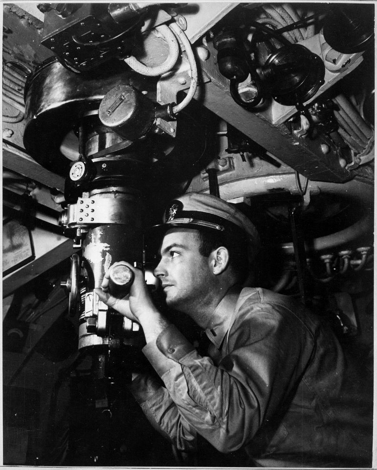 Officer at periscope in control room of submarine. - NARA - 520588