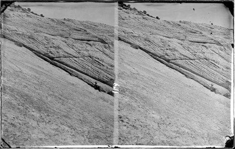 On Waterpocket Creek, Utah. Turtleback sandstone. A man is seated on the ground, right side of - NARA - 518000