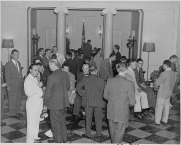 Photograph of a group of unidentified persons milling around in the White House on the occasion of the announcement... - NARA - 199166