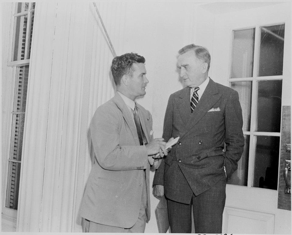 Photograph of a reporter interviewing an unidentified man outside the White House on the occasion of the announcement... - NARA - 199159