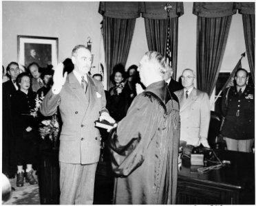 Photograph of Dean Acheson taking the oath of office as Secretary of State in the Oval Office, with Chief Justice... - NARA - 200076