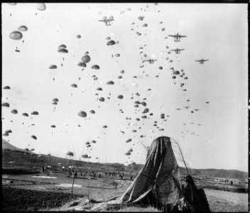 Paratroopers of the 187th RCT (Regimental Combat Team) float earthward from C-119's to cut off retreating enemy units... - NARA - 531401 photo