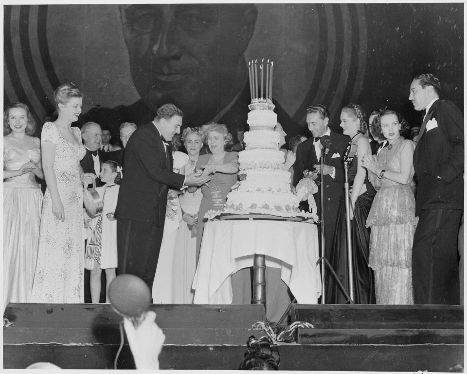 Photograph of First Lady Bess Truman giving a piece of birthday cake to actor William Bendix at a Roosevelt Birthday... - NARA - 199336