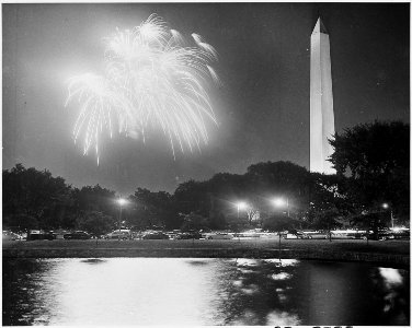 Photograph of fireworks going off in the night sky by the Washington Monument, during ceremonies celebrating the... - NARA - 200339