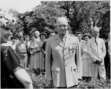 Photograph of General Dwight D. Eisenhower wearing the Distinguished Service Medal, with a group of admiring... - NARA - 199121