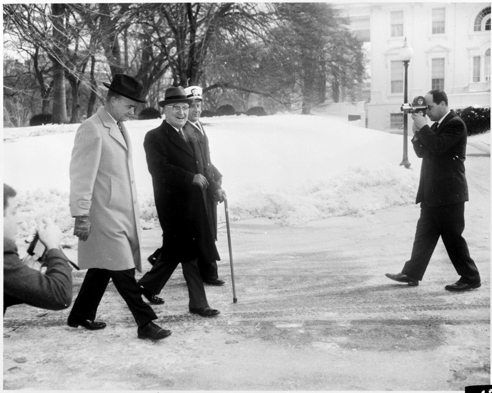 Photograph of former President Harry S. Truman walking on the snow-covered White House grounds, during his first... - NARA - 200439