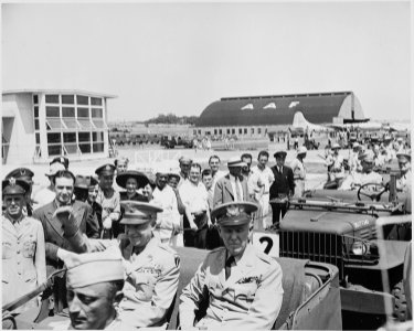 Photograph of General Dwight D. Eisenhower in the back of a jeep with General George C. Marshall, waving to... - NARA - 199128