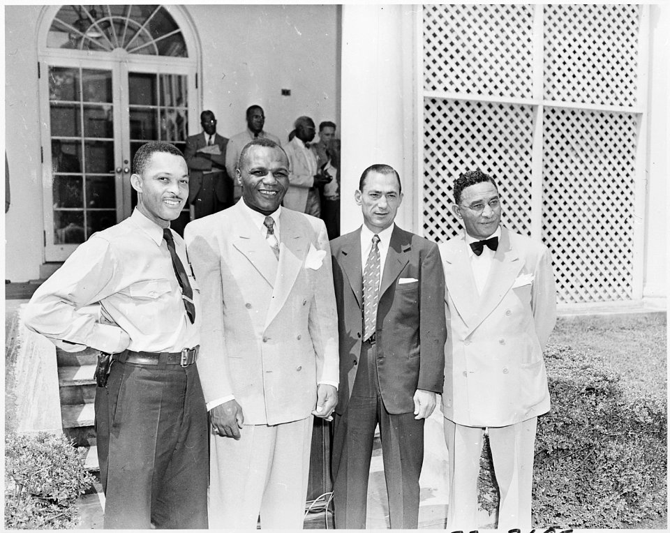 Photograph of Jersey Joe Walcott, the heavyweight champion of the world (second from left), with three other persons... - NARA - 200324