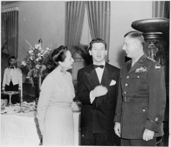 Photograph of movie star Eddie Bracken at a Roosevelt Birthday Ball function, flanked by two unidentified persons. - NARA - 199321