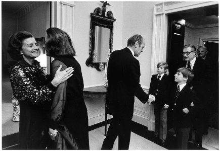 Photograph of First Lady Betty Ford and Happy Rockefeller Embracing as President Gerald Ford Greets Vice President... - NARA - 186787 photo