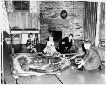 Photograph of Mike, Jack, Steve, and Susan Ford (children of Gerald and Betty Ford) Playing with an Electric Train at... - NARA - 187046 photo