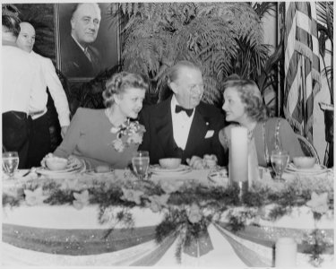 Photograph of movie stars Angela Lansbury, Charles Coburn, and Constance Moore, seated at a table during a Roosevelt... - NARA - 199325