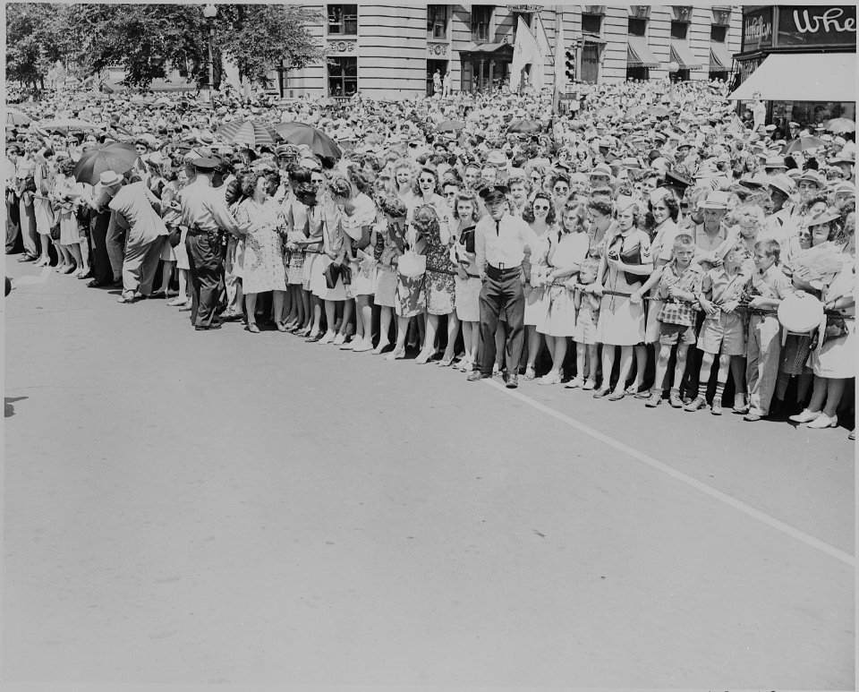 Photograph of police holding back crowds gathered along a Washington street to welcome General Dwight D. Eisenhower. - NARA - 199111