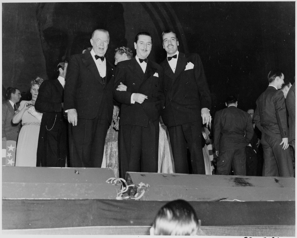 Photograph of movie stars Charles Coburn, Reginald Gardiner, and Cesar Romero, at a Roosevelt Birthday Ball event in... - NARA - 199341