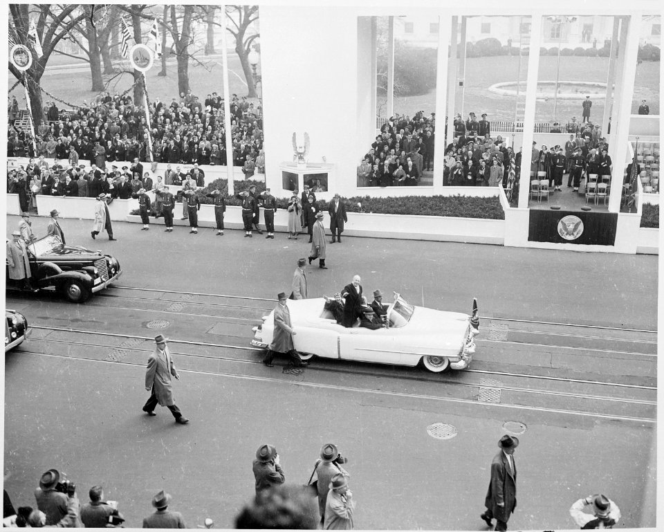 Photograph of President Dwight D. Eisenhower and First Lady Mamie Eisenhower waving to crowds as they ride in the... - NARA - 200425