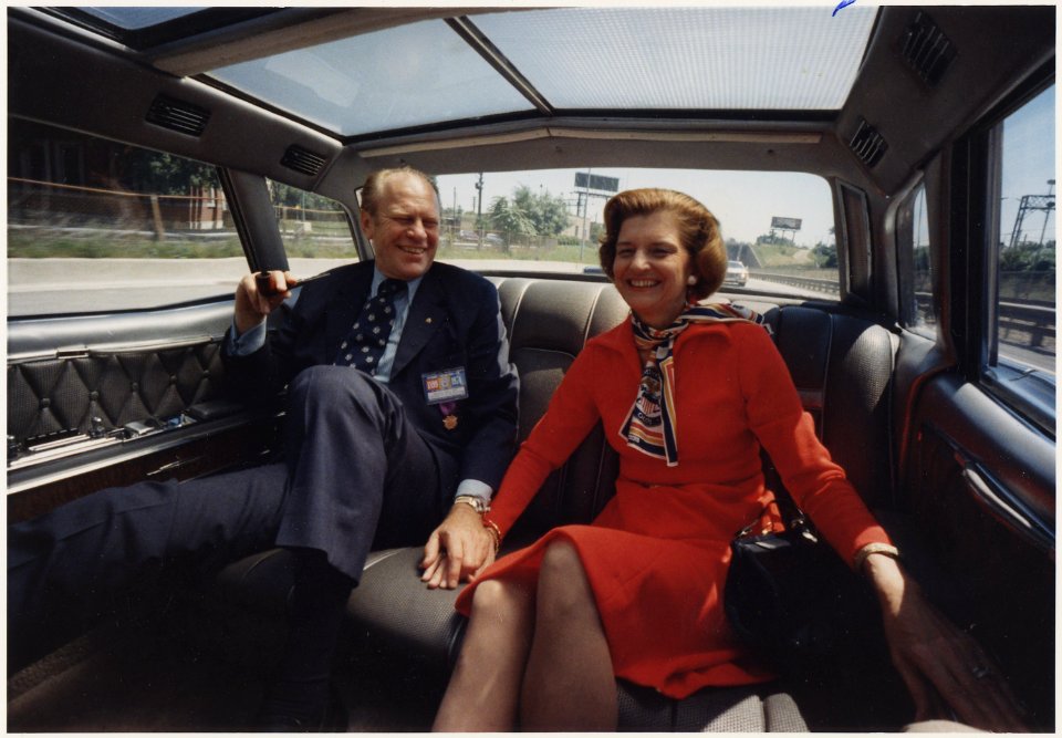 Photograph of President and Mrs. Ford Holding Hands While Riding in the President's Limousine on a Chicago, Illinois... - NARA - 186761