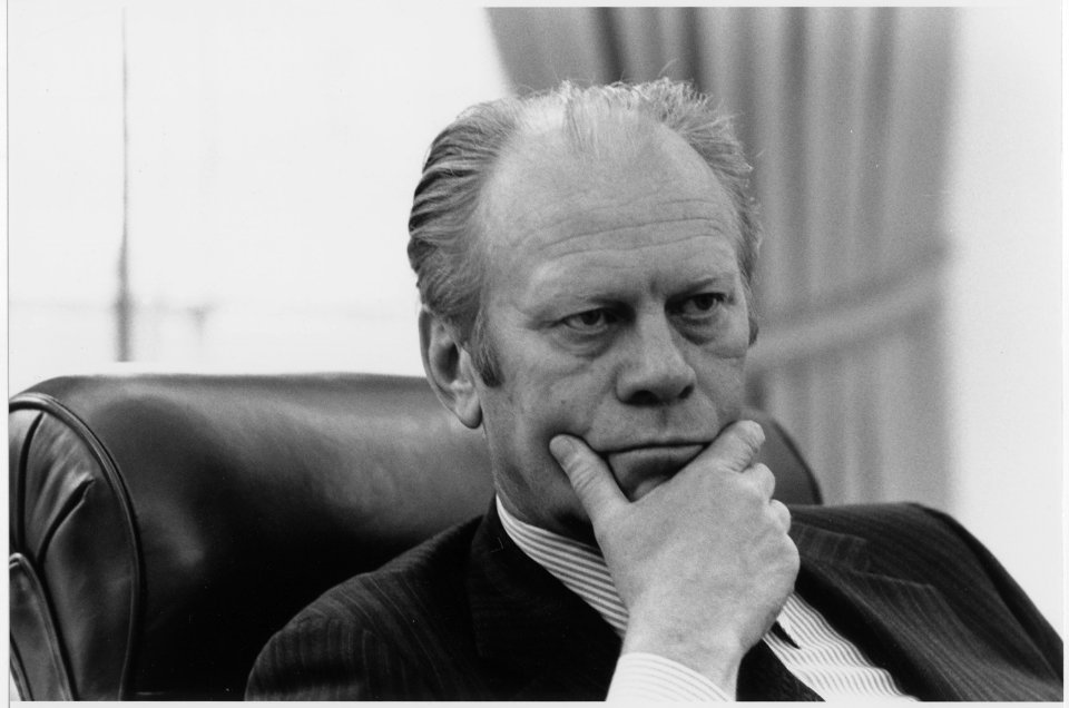 Photograph of President Gerald R. Ford Listening to a Briefing by Secretary of State Henry A. Kissinger on the... - NARA - 186803