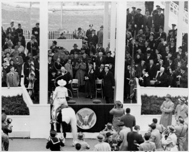 Photograph of President Dwight D. Eisenhower being lassoed by a cowboy while reviewing the Inaugural parade in... - NARA - 200422