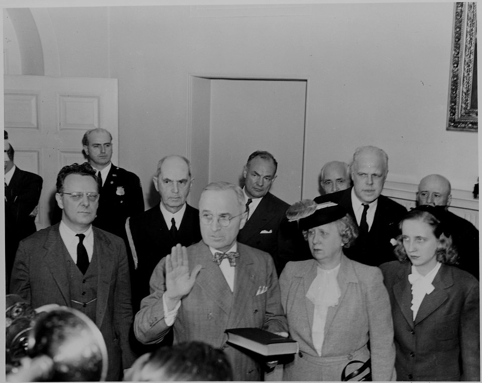 Photograph of President Harry S. Truman taking the oath of office, 7-09 p.m. Bess and Margaret Truman stand beside... - NARA - 199069
