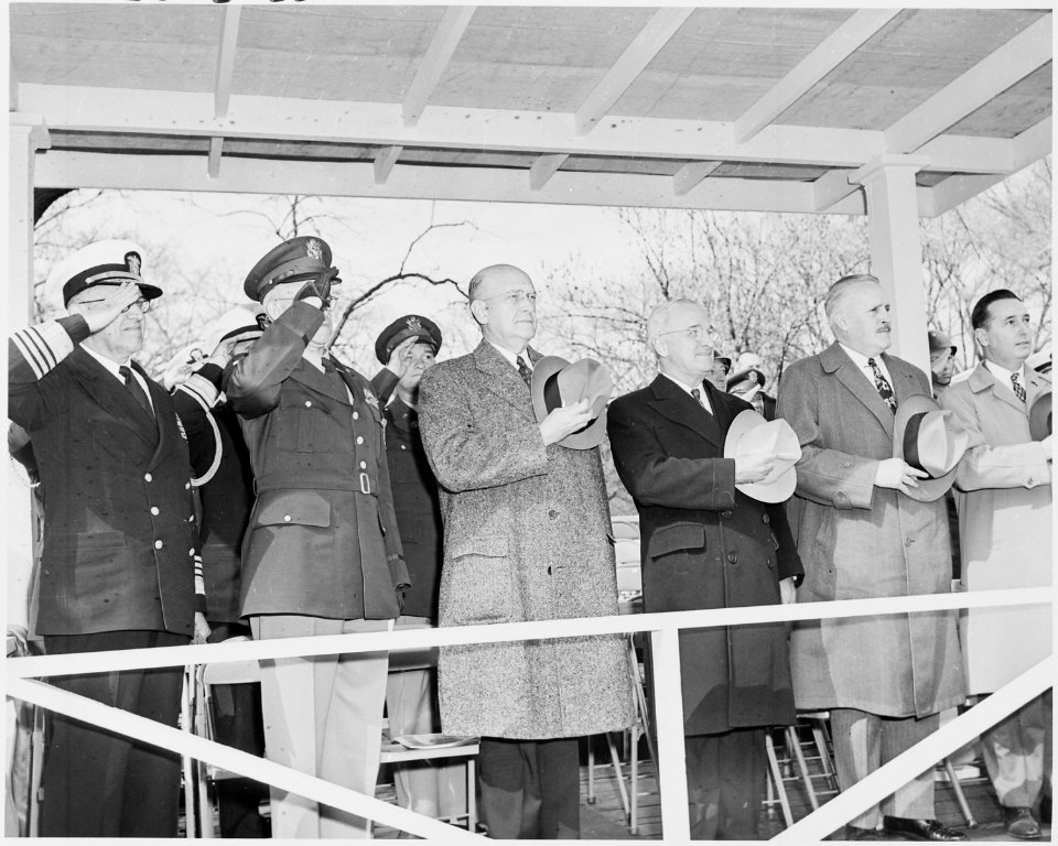 Photograph of President Truman and other dignitaries on the reviewing stand, saluting during the Army Day parade. - NARA - 200106