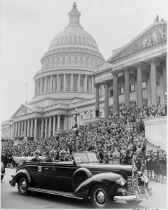 Photograph of limousine carrying Admiral Chester Nimitz past a large crowd of applauding spectators at the U.S. Capitol. - NARA - 199202 photo
