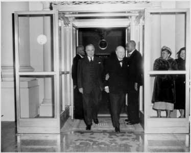 Photograph of President Truman and British Prime Minister Winston Churchill stepping outside the White House. - NARA - 200411 photo